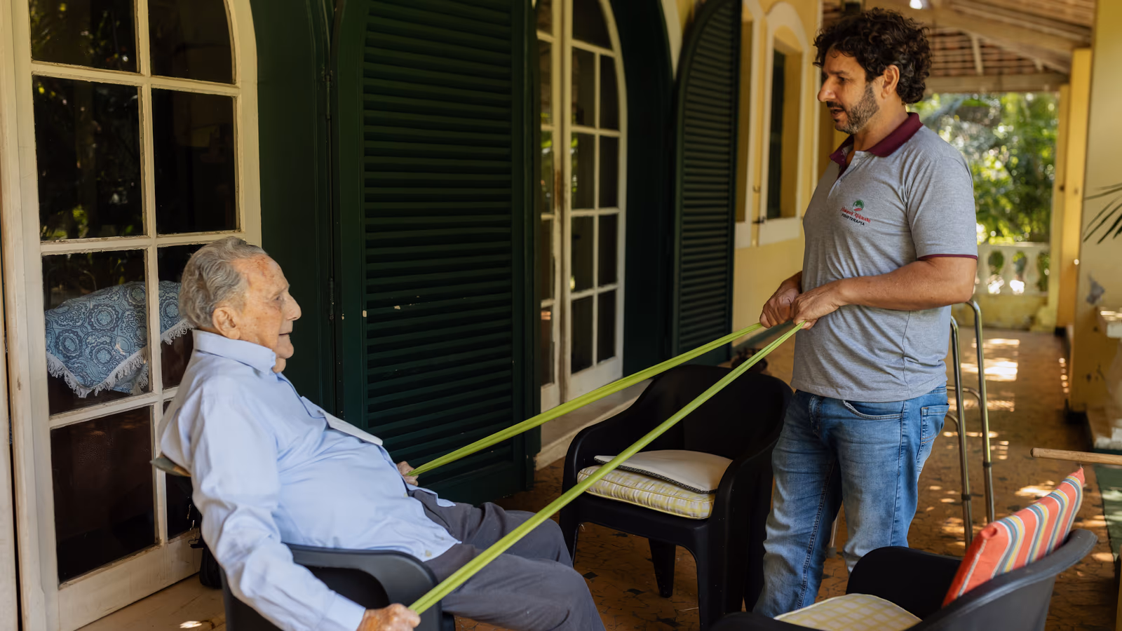 Fisioterapeuta acompanha uma paciente idosa durante uma caminhada ao ar livre