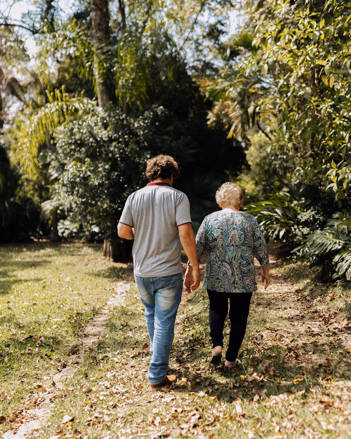 Fisioterapeuta acompanha uma pessoa durante uma caminhada ao ar livre